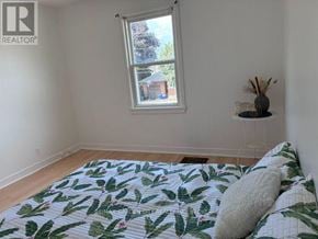 Welland (Lincoln/Crowland) multi-family for rent - A bedroom with a bed, a window, and a wall-mounted shelf.