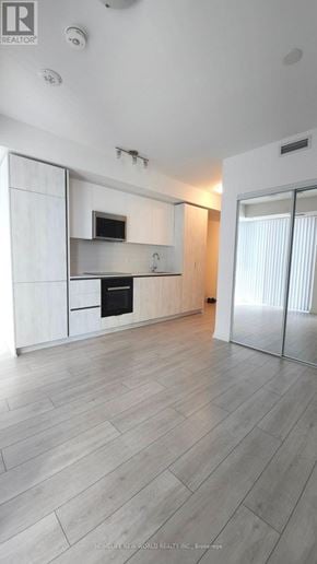 Toronto (Waterfront Communities) condo for rent - A modern kitchen with white cabinets and a wooden floor.