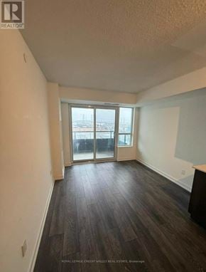 Pickering (Bay Ridges) condo for rent - A room with wooden flooring and a large window overlooking a cityscape.