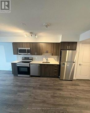 Pickering (Bay Ridges) condo for rent - A modern kitchen with stainless steel appliances and wooden cabinets.