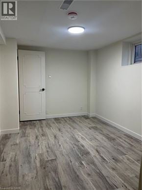 Kitchener apartment for rent - A room with a wooden floor and a white door.