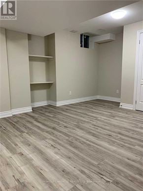 Brampton (Bram East) apartment for rent - A room with wooden flooring and shelving units.