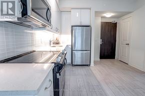 Toronto (Mimico) condo for rent - A modern kitchen with a refrigerator, microwave, and oven.