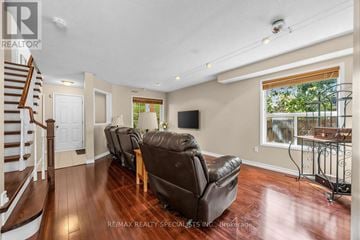 Mississauga (Meadowvale Village) apartment for rent - A living room with a brown leather couch and a wooden staircase.