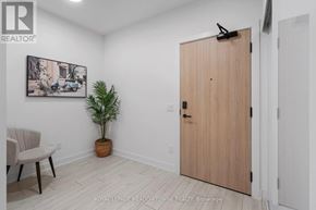 Toronto (Waterfront Communities) condo for rent - A room with a wooden door, a plant, and a painting on the wall.