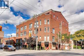 Toronto (Niagara) condo for rent - A large red brick building with a sign that says "REALTOR" on it.