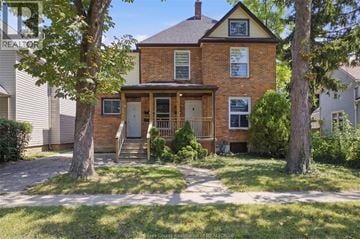 Windsor apartment for rent - A brick house with a porch and a tree in front.