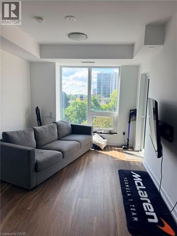 Kitchener condo for rent - A living room with a grey couch and a Formula 1 mat on the floor.