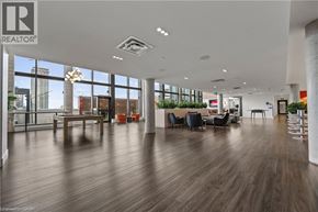 Kitchener condo for rent - A spacious office with wooden floors and large windows overlooking the city.