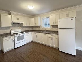 Surrey apartment for rent - A kitchen with white appliances and wooden floors.