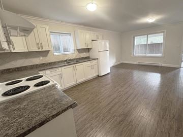 Surrey apartment for rent - A kitchen with a stove top oven and a refrigerator.