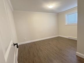 Surrey apartment for rent - A room with light brown flooring and white walls.