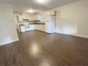Surrey apartment for rent - A kitchen with white appliances and wooden floors.