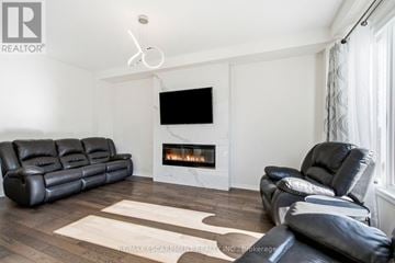 Hamilton (Stoney Creek Mountain) apartment for rent - A living room with a black leather couch and a fireplace.
