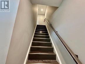 St. Catharines (Oakdale) apartment for rent - A staircase with a metal railing and wooden steps.