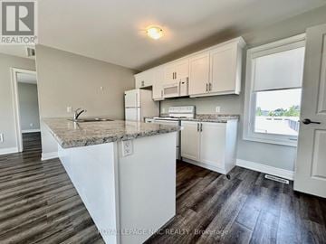 St. Catharines (Oakdale) apartment for rent - A kitchen with white cabinets and a granite countertop.