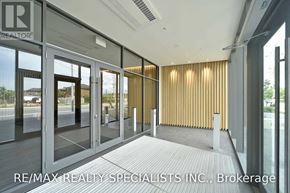 Toronto (Englemount-Lawrence) condo for rent - A modern office space with glass doors and a wooden wall panel.