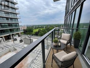 Toronto (Humber Heights) condo for rent - A balcony with a table and chairs overlooks a cityscape.