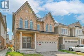 Cambridge apartment for rent - A brick house with a garage door is for sale.
