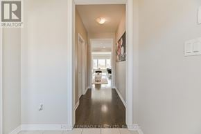 Cambridge apartment for rent - A hallway with a white wall and a wooden floor leading to a kitchen.