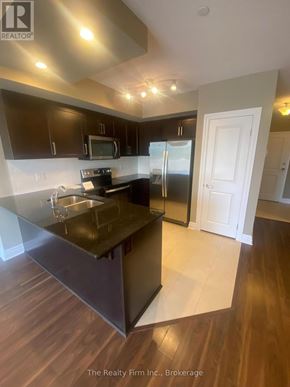 Woodstock (Woodstock - South) condo for rent - A kitchen with a black counter top and wooden floors.