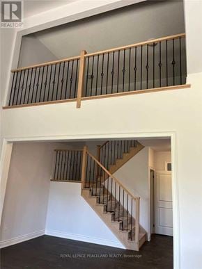 Uxbridge townhouse for rent - A staircase with a wooden handrail and black balusters.