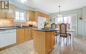 Brampton (Northwest Sandalwood Parkway) apartment for rent - A kitchen with wooden cabinets and a black countertop.