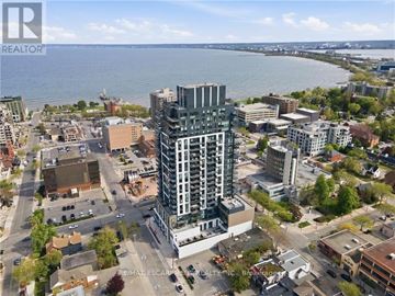 Burlington (Brant) condo for rent - A cityscape with a large building in the center and a body of water in the background.