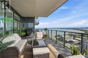 Burlington (Brant) condo for rent - A balcony with a table and chairs overlooking a cityscape.