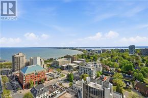 Burlington (Brant) condo for rent - A cityscape with a body of water in the background and a clear sky.