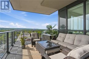 Burlington (Brant) condo for rent - A balcony with a table, chairs, and a couch overlooking a street.