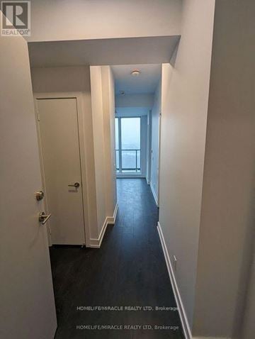 Brampton (Northwest Brampton) condo for rent - A hallway with a white door and a window at the end.