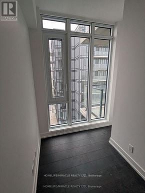 Brampton (Northwest Brampton) condo for rent - A room with a large window and a view of a building outside.