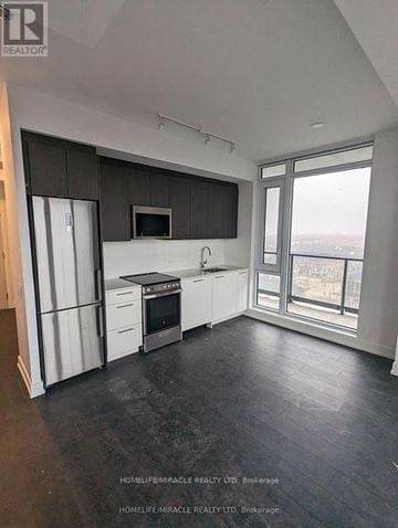 Brampton (Northwest Brampton) condo for rent - A kitchen with white cabinets and a black countertop.
