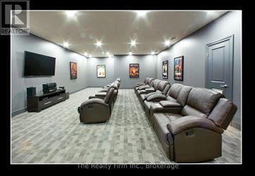 Woodstock (Woodstock - South) condo for rent - A living room with a row of brown leather couches and a flat screen TV mounted on the wall.