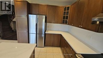 Vaughan (Patterson) apartment for rent - A kitchen with wooden cabinets and a stainless steel refrigerator.