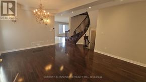 Vaughan (Patterson) apartment for rent - A spacious room with a wooden floor and a chandelier.