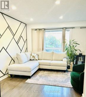 Mississauga (Erin Mills) house for rent - A white couch with a green chair and a rug in front of a window.