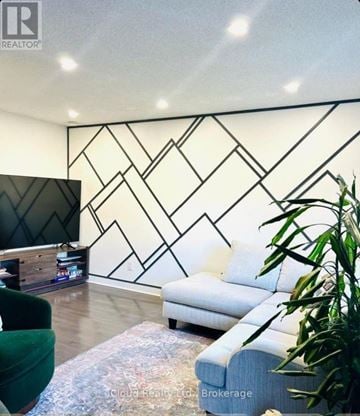 Mississauga (Erin Mills) house for rent - A living room with a white sofa and a black and white geometric wall design.