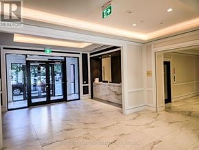 Toronto (Humber Heights) condo for rent - A hallway with marble floors and a green exit sign.