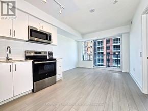 Toronto (Humber Heights) condo for rent - A kitchen with white cabinets and a black oven.