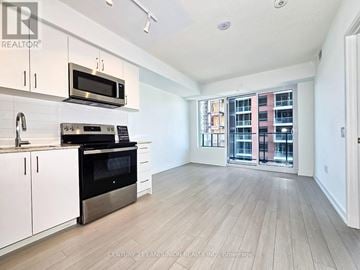 Toronto (Humber Heights) condo for rent - A kitchen with white cabinets and a black oven.