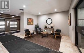 Guelph (Downtown) condo for rent - A waiting area with a black carpet and brown chairs.