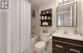 Toronto (Niagara) condo for rent - A white toilet sits in a bathroom with a white shower curtain.