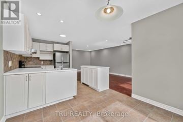 Ottawa townhouse for rent - A kitchen with white cabinets and a tiled backsplash is for sale.