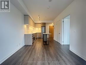 Vaughan (Beverley Glen) condo for rent - A spacious, empty room with wood flooring and white walls.