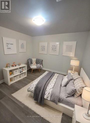 Barrie (North Shore) multi-family for rent - A bedroom with a bed, a chair, and a shelf with toys on it.