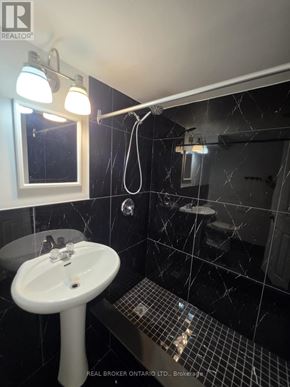 Barrie (North Shore) multi-family for rent - A bathroom with a sink, mirror, and tiled floor.