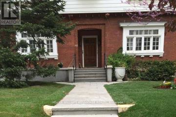 Toronto (Casa Loma) multi-family for rent - A red brick house with a white window and a brown door.