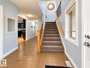 Edmonton apartment for rent - A hallway with a staircase and a mirror on the wall.